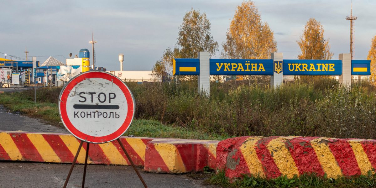 A road block in Bachevsk, Ukraine with a large STOP sign in front.
