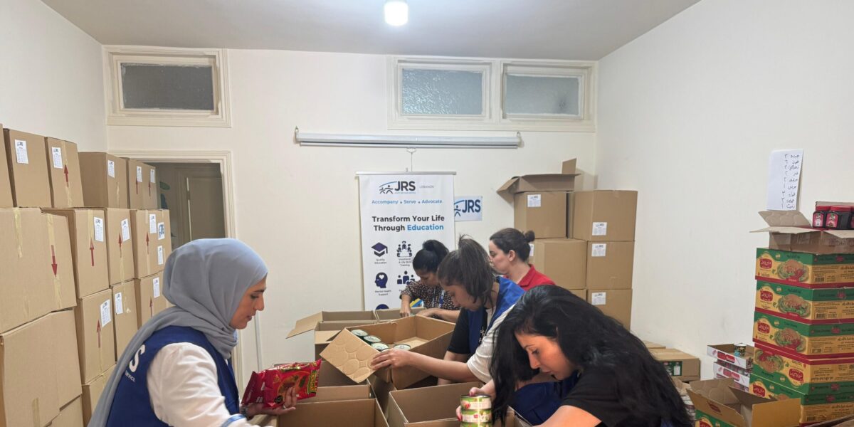 JRS staff in Lebanon supporting refugees and other forcibly displaced people with food assistance and other emergency relief amid escalating violence in Lebanon. The staff is packing boxes with various nonperishable food items.