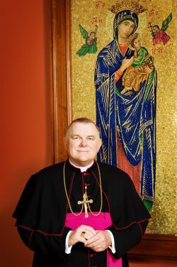 Ignatian Migration Dialogue | Guest Speaker, Archbishop Thomas Wenski standing in front of a Madonna portrait